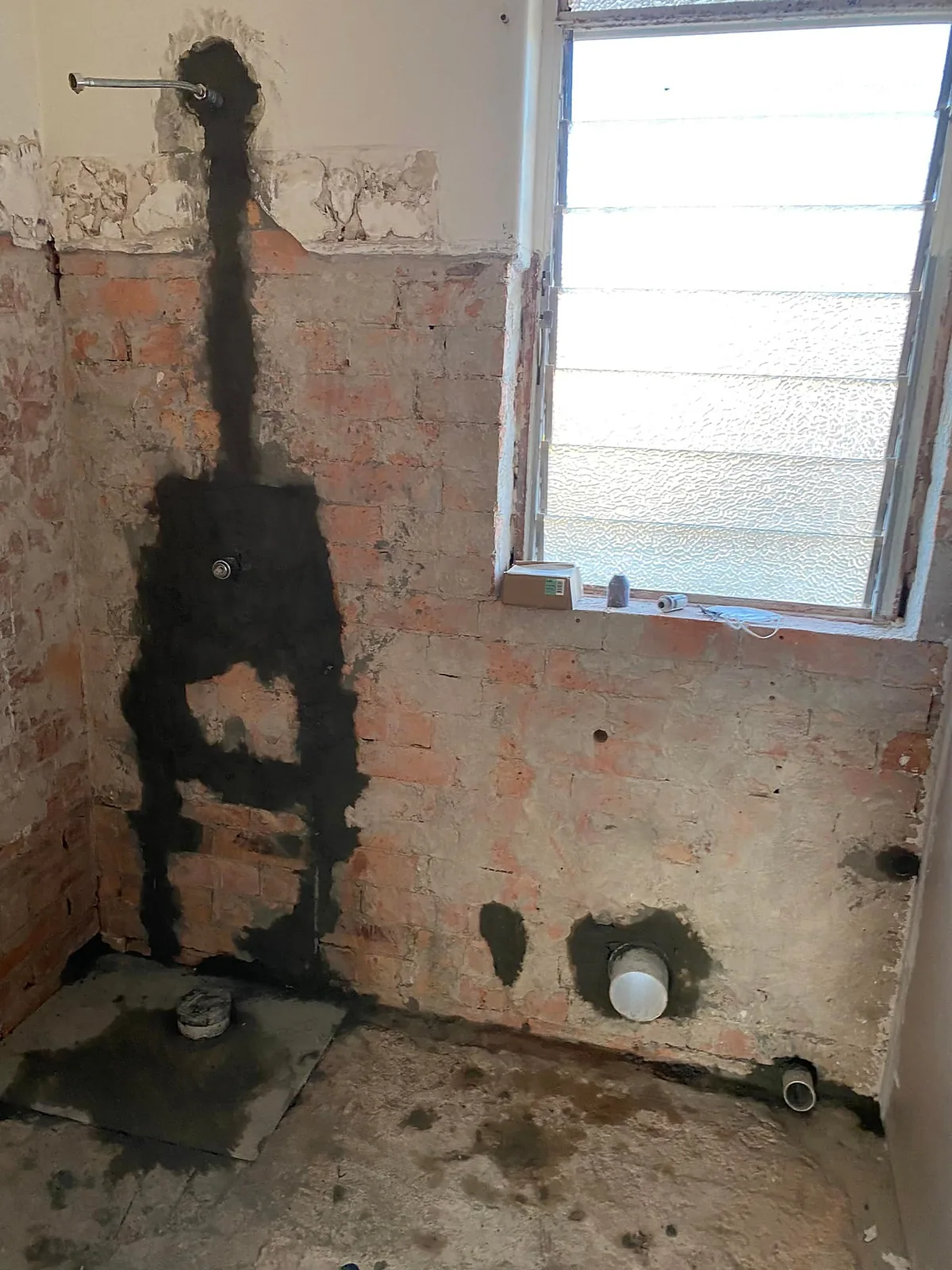 Old bathroom stripped back to the bare brick wall