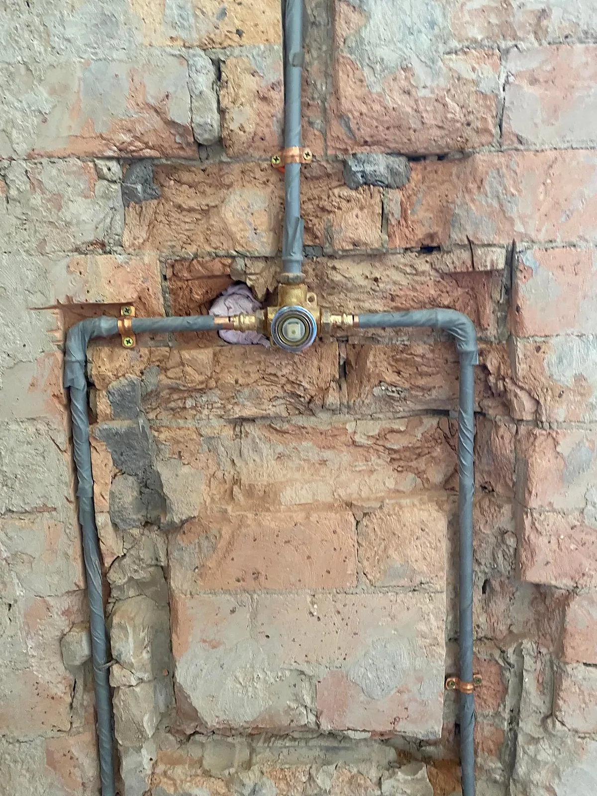 Shower mixer rough-in with new pipework chased into a brick wall